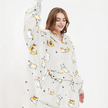 Heated Hoodie Blanket Black variant — lifestyle shot worn on couch showing cozy wearable blanket style